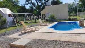 una piscina con 2 sillas y un columpio en Cabaña Solares en La Silleta