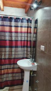 baño con lavabo y cortina de ducha en Cabaña Solares en La Silleta