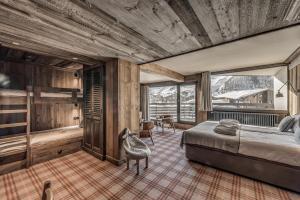 a bedroom with a bed and a table and chairs at Hotel & Spa Le Val d'Isère in Val-d'Isère +37 photos