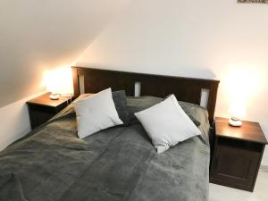 1 dormitorio con 1 cama con 2 mesitas de noche y 2 lámparas en Apartamentai Nidos centre Taikos g, en Nida