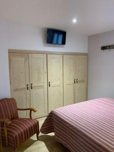 - une chambre avec un lit et une télévision murale dans l'établissement Apartament Forn d'ITA, à Esterri d'Àneu