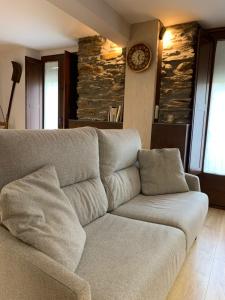 - un salon avec un canapé et un réveil sur le mur dans l'établissement Apartament Forn d'ITA, à Esterri d'Àneu