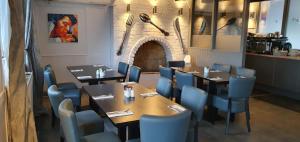 The Moorcock Inn في Littleborough: غرفة طعام مع طاولات وكراسي زرقاء في مطعم