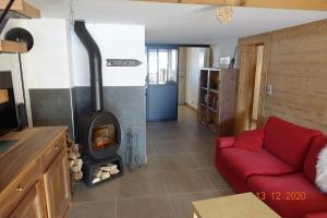a living room with a red couch and a wood stove at Appartement ensoleillé in Morzine
