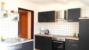 a kitchen with black cabinets and a sink at Ferienwohnung Brandstatter in Windischgarsten