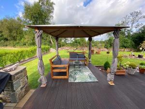 una terraza de madera con cenador en 2 Caragh Glen en Killorglin