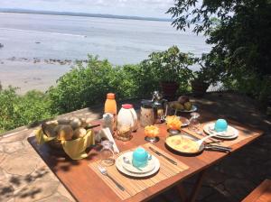 a picnic table with food and a view of the beach at Pousada VillaBahia Morro in Morro de São Paulo