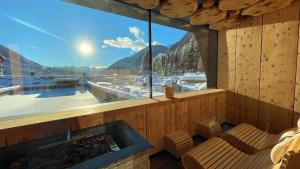 a room with a large window and a hot tub at FONTIS luxury spa lodge in Santa Maddalena in Casies Valbassa