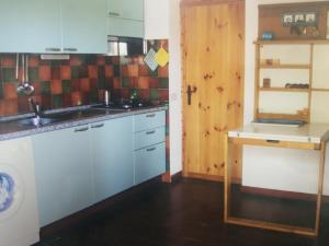 una cucina con armadi blu e una porta in legno di Villa Chiara Villetta con giardino IUN 4807 a Porto Pollo