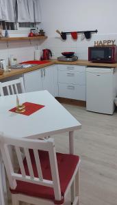 a kitchen with a white table and a red chair at Hamedina de Silvina in Kafr Sābā +11 photos