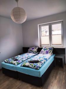 a bed in a bedroom with a blue mattress and pillows at Apartamenty As Szczyrk Centrum in Szczyrk
