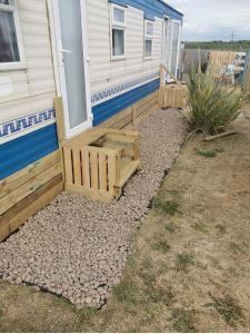 a house with a porch and a bench next to it at Heacham South Beach static caravan in Heacham