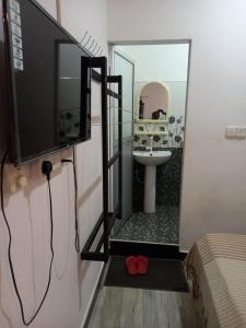 a bathroom with a sink and a mirror at Villa Luxez in Kalmunaikudiyiruppu