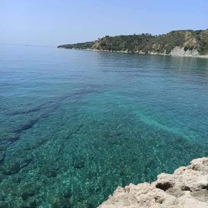 a large body of water with a rocky shore at Kefallonia Bay Resort in Spartià