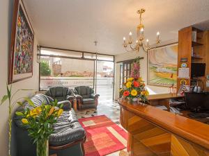 a living room with a couch and a desk at Hotel Tuvalu in Paipa