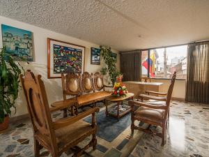 a living room with chairs and a table and a couch at Hotel Tuvalu in Paipa