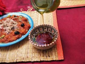 Dar El Kasba Bizerte في بنزرت: كأس من النبيذ يتم سكبه في وعاء من الطعام