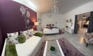 a living room with a white couch and a bedroom at Appartment Rosengarten in Baden