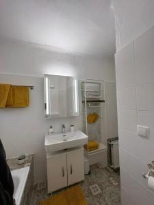 a white bathroom with a sink and a toilet at Appartment Rosengarten in Baden
