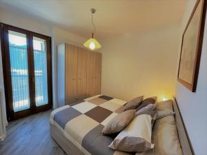 una camera con un letto con una coperta a scacchi di Appartamento LaBaitaCase Contrada Pradella - Affitti Brevi Italia a Sondrio