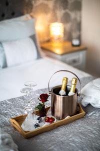 a tray with champagne bottles and glasses on a bed at Keppel Gate B&B - Silver Birch Ensuite Room in Overseal