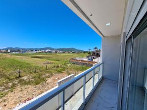 einen Balkon mit Blick auf ein Feld in der Unterkunft Recanto Brisa e Mar in Palhoça