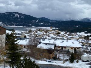 uma aldeia coberta de neve com montanhas ao fundo em Studio cabine Les Angles Capcir em Les Angles