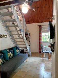 a living room with a staircase and a couch at le colibri ble in Sainte-Anne