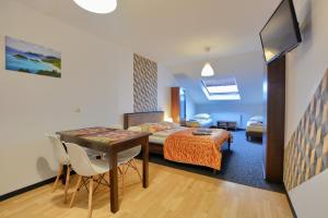 um quarto com uma cama, uma mesa e cadeiras em Apartdom em Krynica-Zdrój