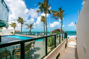 a balcony with a pool and the beach at Kings Flat - Apartamentos com conforto beira mar in Natal