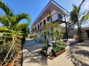 a house with palm trees and plants in front of it at Alojamiento Bityn in Paso Nuevo