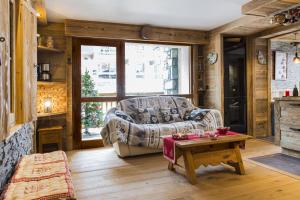 a living room with a couch and a table at ski au pied, 3ch 2Sdb Garage Terrasse in Courchevel