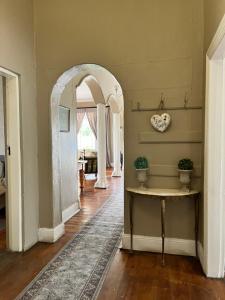 a hallway with a table and an archway in a house at khaya4u Guesthouse in Dundee