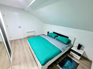 a white bedroom with a large bed with green pillows at Apartment Djurdjic in Pale