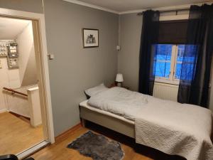 um pequeno quarto com uma cama e uma janela em Buskbacken Logi em Bollnäs