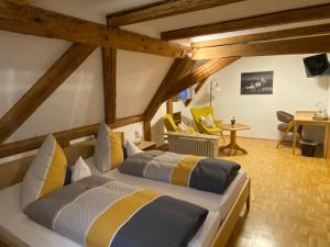 1 dormitorio con 2 camas, mesa y sillas en Gasthof - Pension - Adler, en Weiler-Simmerberg