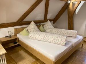 a bed with pillows on it in a room at Gasthof - Pension - Adler in Weiler-Simmerberg