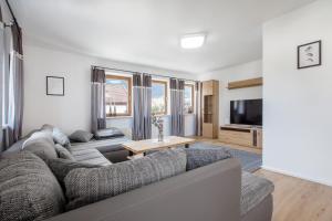 a living room with a couch and a tv at Ferienwohnung zum Traumblick in Pfronten