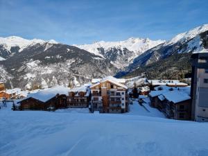 a ski lodge in the snow with mountains in the background at ski au pied, 3ch 2Sdb Garage Terrasse in Courchevel