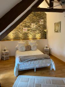 a bedroom with a bed with a stone wall at La Vieille Boulangerie in Langourla +5 photos