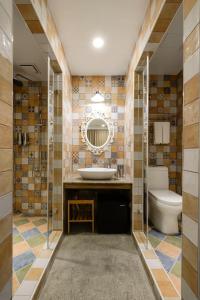 uma casa de banho com um WC, um lavatório e um espelho. em Napas Hotel em Taichung