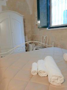 2 rouleaux de serviettes assis au-dessus d'un lit dans l'établissement Il Vico, à Lecce