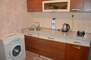 a kitchen with a washing machine and a sink at Apartment Miorita in Chişinău