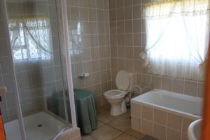 een badkamer met toilet, bad en wastafel bij Tulip Close in Stilbaai +2 foto's