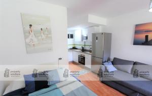 eine Küche und ein Wohnzimmer mit einem Kühlschrank in der Unterkunft 102 Estudio en Jupiter Apartmentos - Piscina y Playa - Excelente Ubicación in Benalmádena