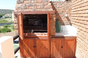 een houten doos aan de zijkant van een bakstenen gebouw bij Tulip Close in Stilbaai