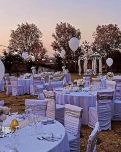 un groupe de tables avec des tables et des chaises blanches dans l'établissement Sogno Proibito, à Meldola