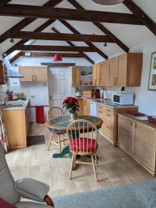 a kitchen with a table and chairs in a room at The Cottage, Little Trembroath in Stithians