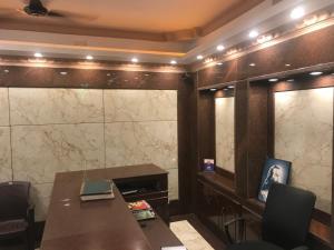 a room with a table and chairs and a wall at Hotel Rehoboth in Kanyakumari