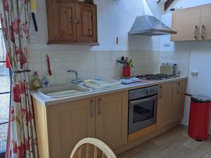 a kitchen with a sink and a stove at The Cottage, Little Trembroath in Stithians